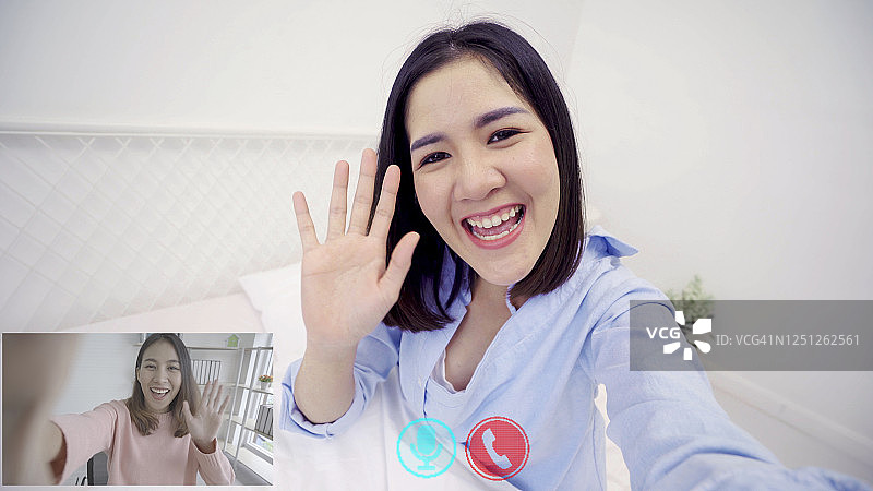 快乐的亚洲女性朋友在智能手机上进行视频通话并看着镜头图片素材