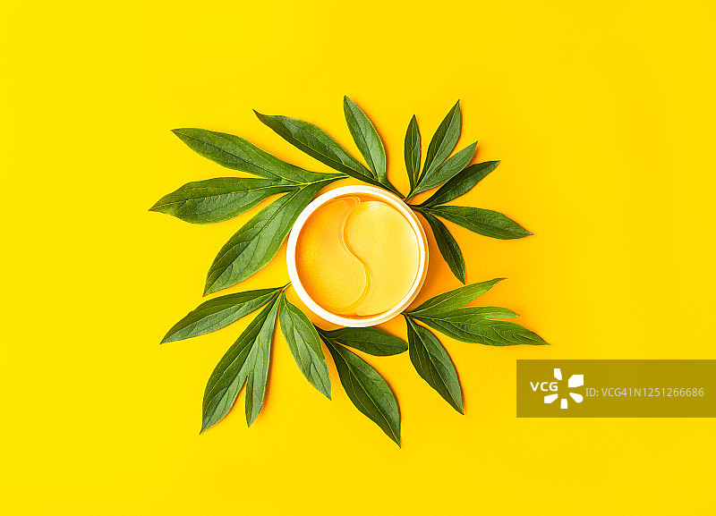 黄色背景上的金色贴片，天然花卉提取物化妆品图片素材