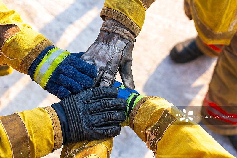 消防员们手牵着手，展示强大的团队合作精神和成功图片素材