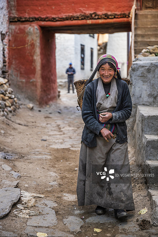 尼泊尔木斯塘上部的藏族妇女， carrying basket图片素材