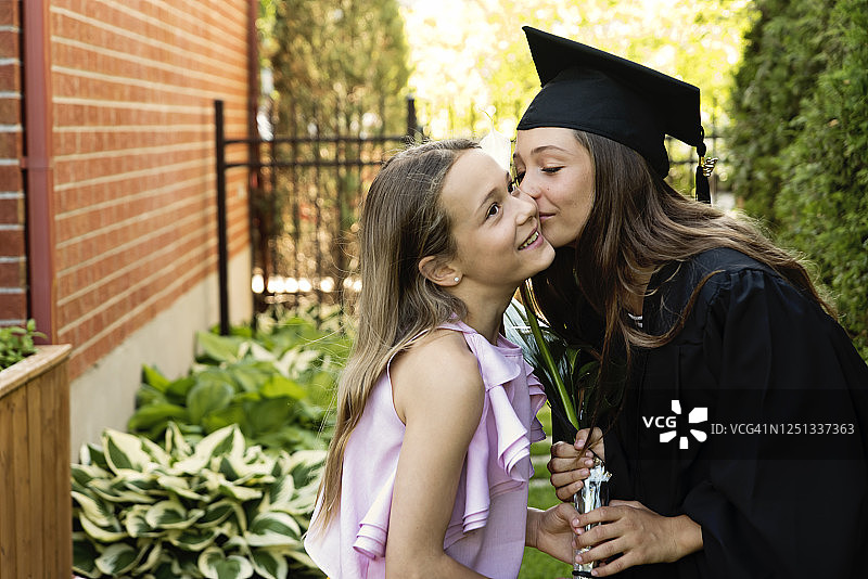 少女在后院拍摄小学毕业照图片素材