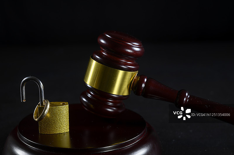 分居概念：打开的锁，旁边放着结婚戒指和法官木槌图片素材