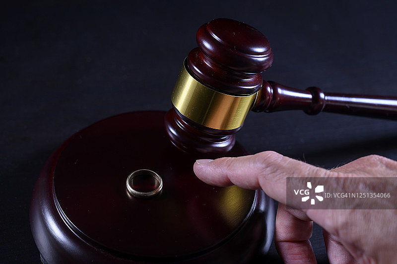 男人要拿走一枚金婚戒指，法官的木槌，夫妻分居程序图片素材