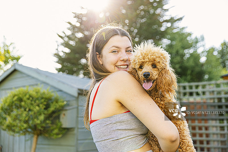 少女拥抱宠物贵宾犬图片素材