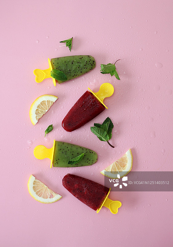 猕猴桃草莓汁自制冰淇淋，粉色背景上点缀柠檬片和薄荷叶图片素材