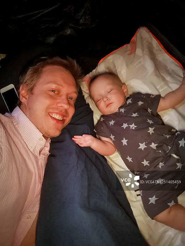 在挪威哈尔萨，爸爸和熟睡的女儿自拍图片素材