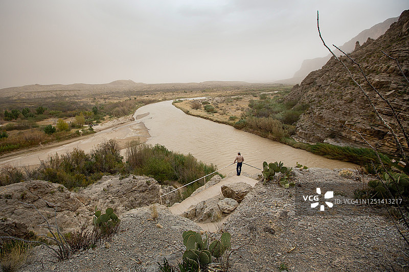 男人观看沙尘暴袭击格兰德河 - 大弯国家公园图片素材
