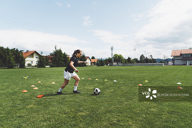 在足球场上练习足球的女人图片素材
