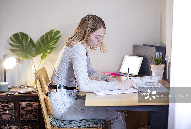 十六岁的女孩在房间里做功课图片素材