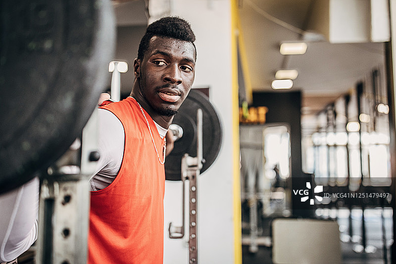 在健身房用重物训练的年轻男子排球运动员图片素材