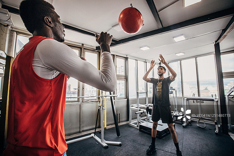 两个年轻男人排球运动员用药球锻炼图片素材