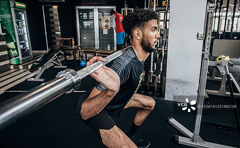 一名男排球运动员在健身房进行负重训练图片素材