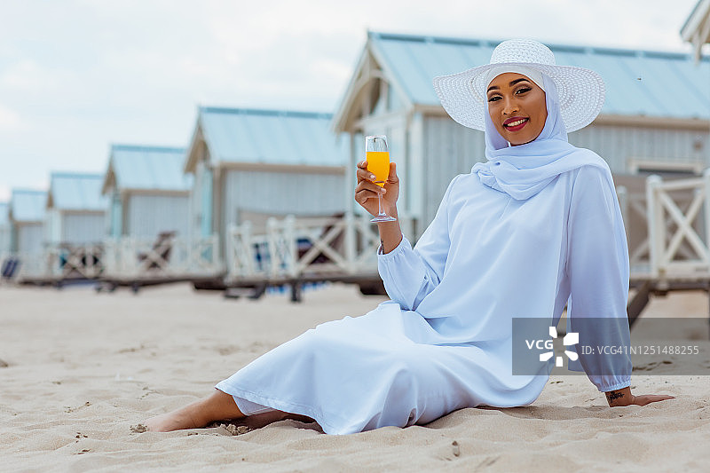 在海滩上戴着头巾的美丽穆斯林妇女图片素材