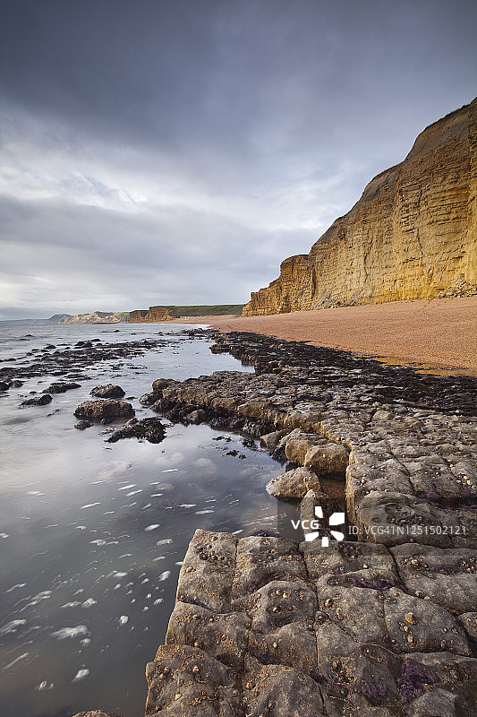 英国多塞特郡伯顿布拉德斯托克砂岩悬崖和浪蚀台图片素材