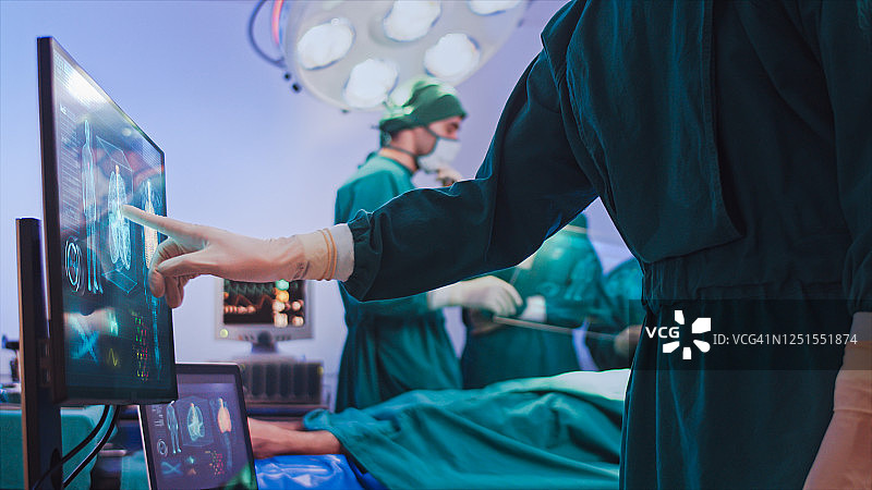 手术室里使用全息虚拟屏幕界面的医生图片素材