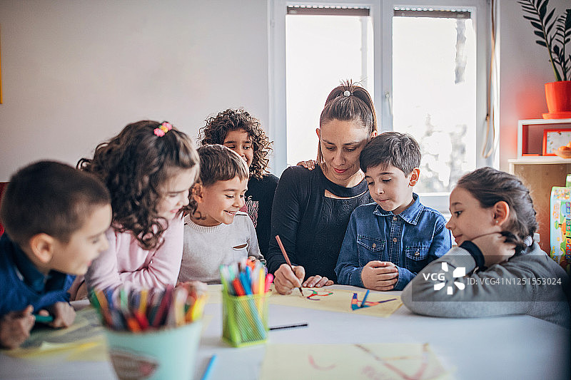 私立学校里和孩子们一起上课的女教师图片素材
