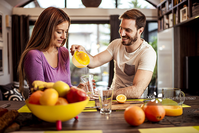 早上一起榨橙汁的年轻夫妇图片素材