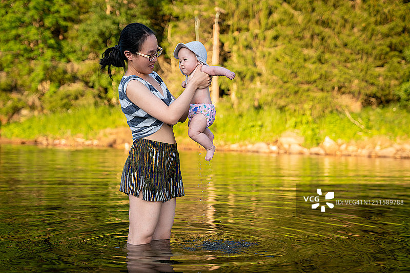 在挪威索克内达尔的湖中，母亲给女儿洗澡图片素材