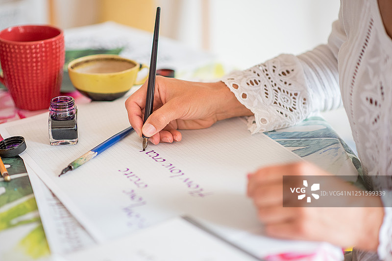 美丽女人用书法在纸上写字图片素材