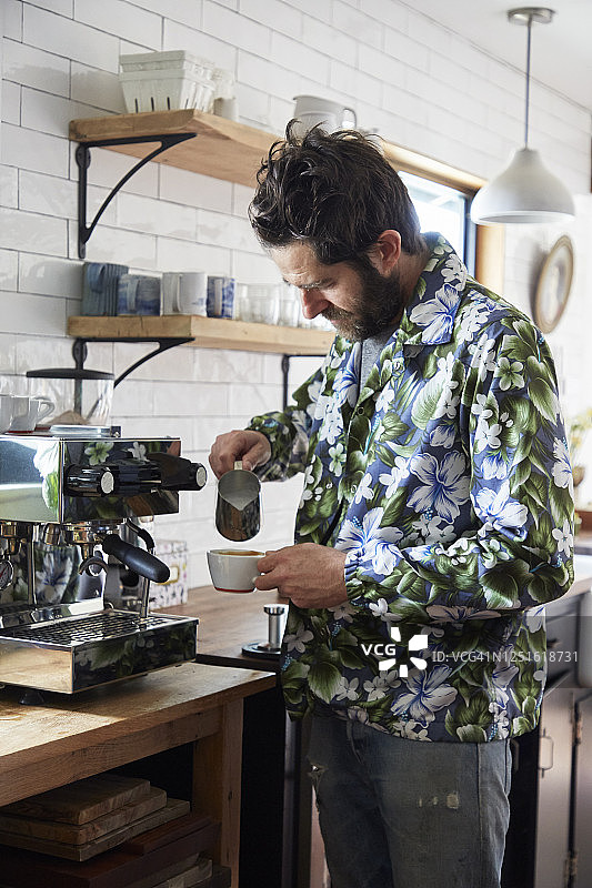 穿夏威夷衬衫的男人在家制作卡布奇诺图片素材