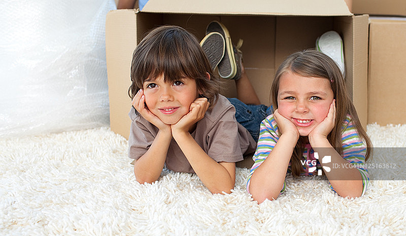 可爱的兄弟姐妹一起玩纸箱图片素材