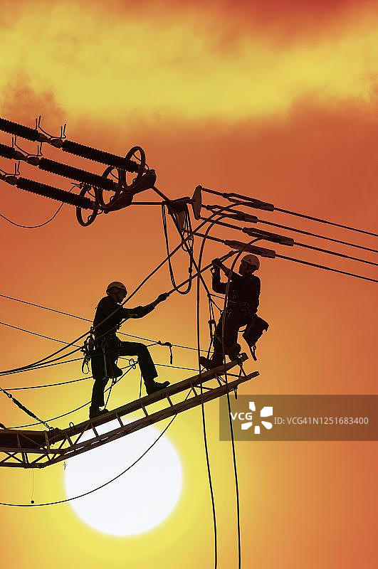 数字合成：高压工程师在德国巴登-符腾堡州高压电塔上工作图片素材
