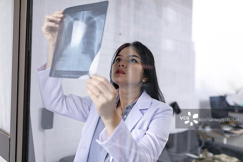 在医院检查X光片的亚洲女医生图片素材