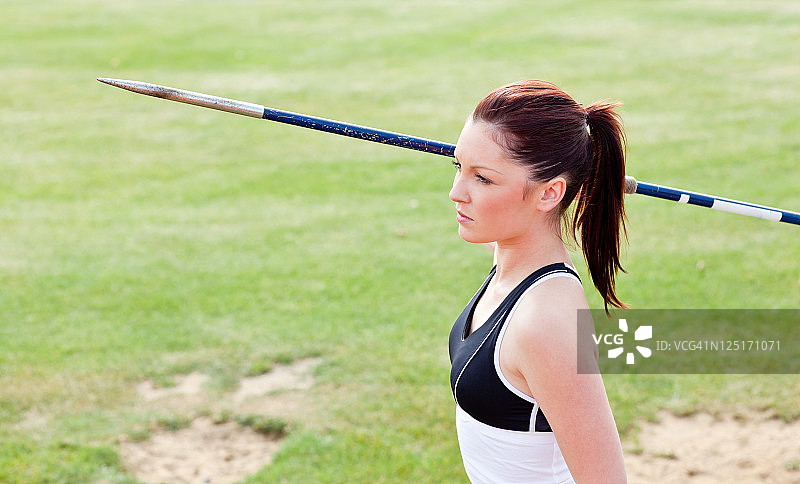 专注的女运动员准备投掷标枪图片素材
