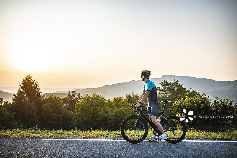 骑自行车男子停下来欣赏山路景色图片素材