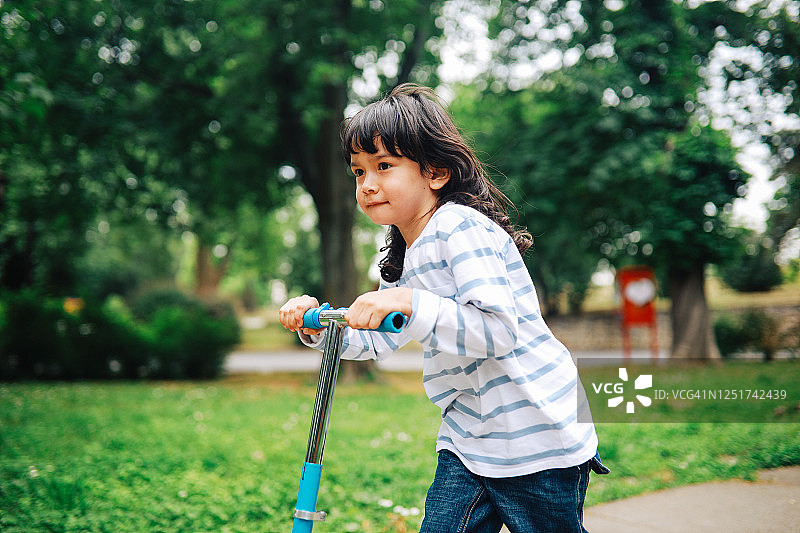儿童在公园里骑滑板车图片素材