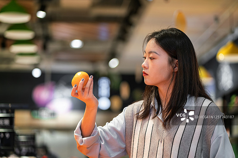 在水果和蔬菜商店购物的亚洲千禧一代女性图片素材