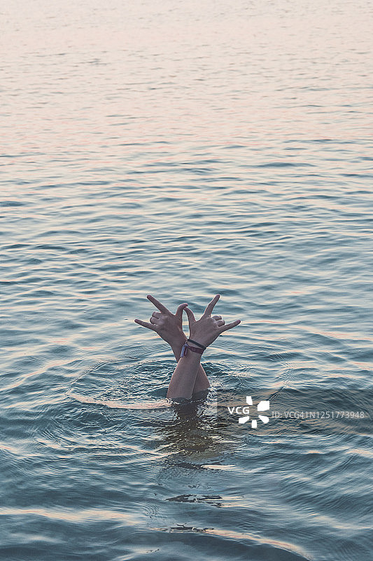 在海中潜水的少女比出摇滚手势图片素材