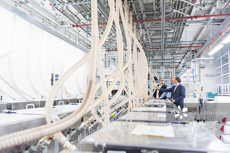 三位商人在工厂进行讨论图片素材