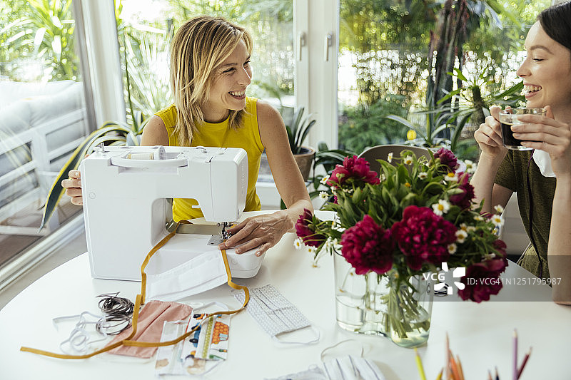 与朋友在家缝制口罩的女人图片素材