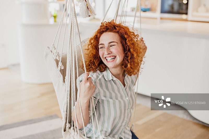 年轻女人在家里的秋千上享受图片素材