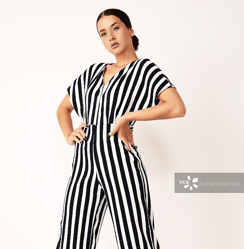 身穿条纹连衣裙的年轻时尚女模特，白色背景图片素材