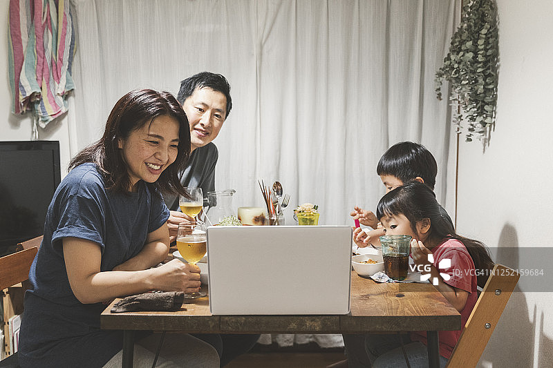 家人在家参加在线视频会议并共进晚餐图片素材