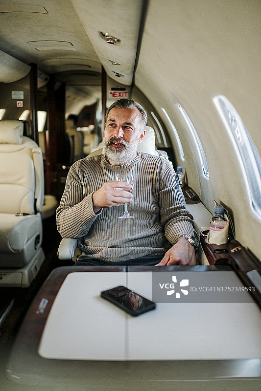 乘坐私人飞机的公司重要人物手持玻璃杯图片素材