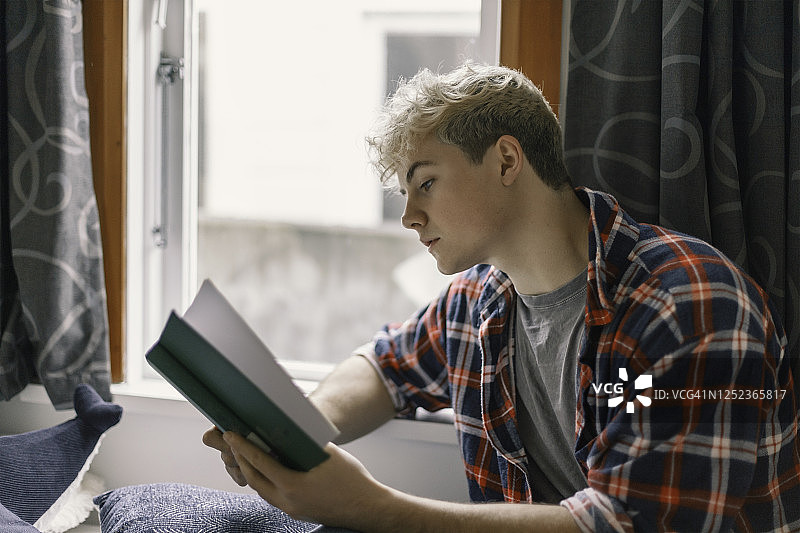 年轻男人在家读书图片素材