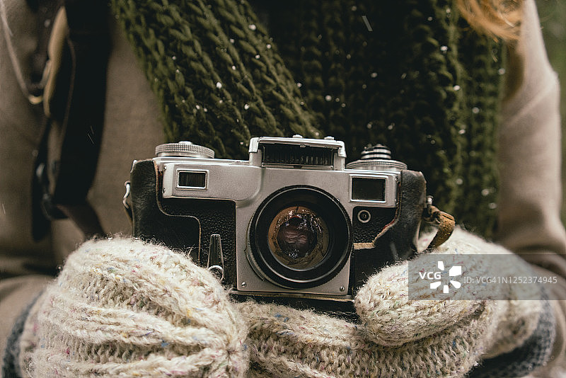 戴连指手套的女人手持复古相机特写图片素材