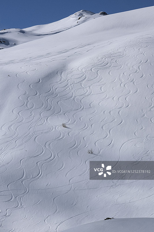 阳光明媚的雪山坡上的下坡滑雪道，达沃斯，瑞士图片素材