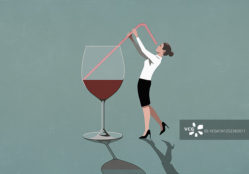 女商人用吸管从大酒杯里喝东西图片素材