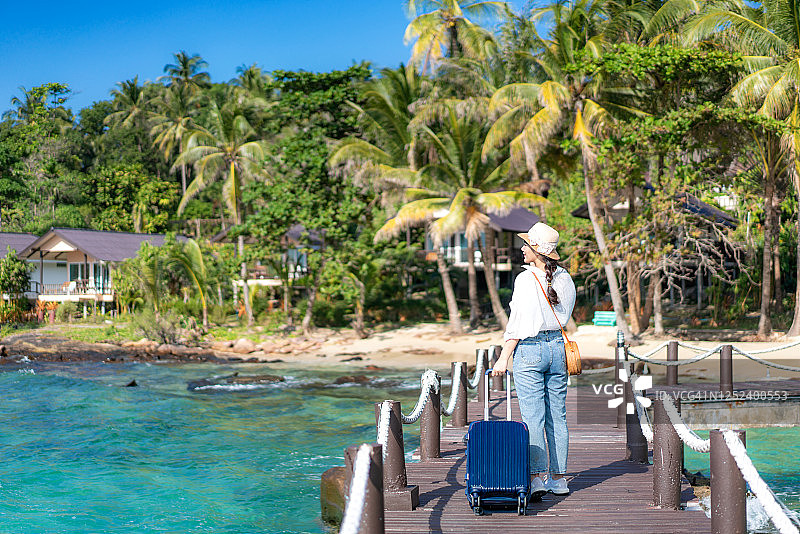 在泰国Trat海滩酒店前木栈道上行走的美丽亚洲女子图片素材