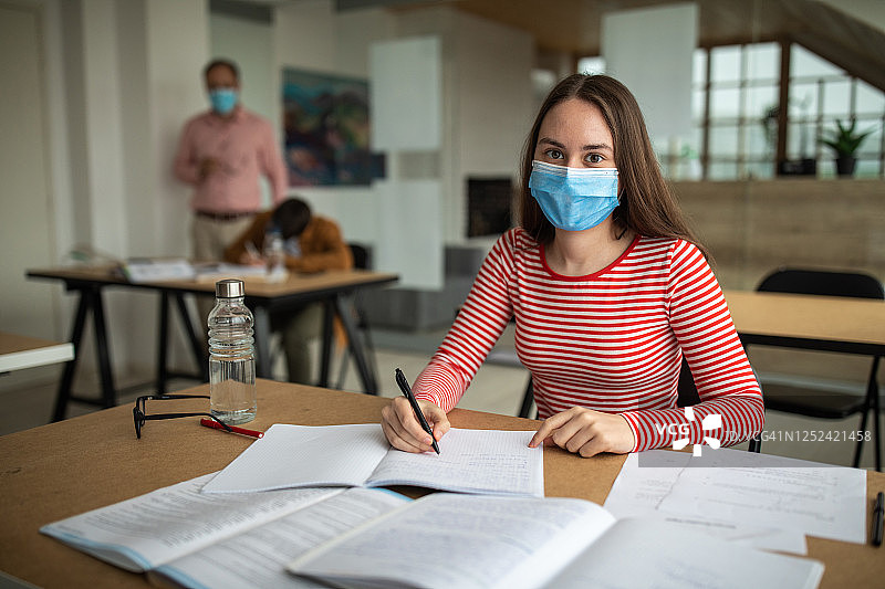 戴防护口罩的女学生在教室里图片素材