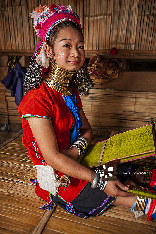 长颈喀伦族年轻女子在传统织布机上编织图片素材