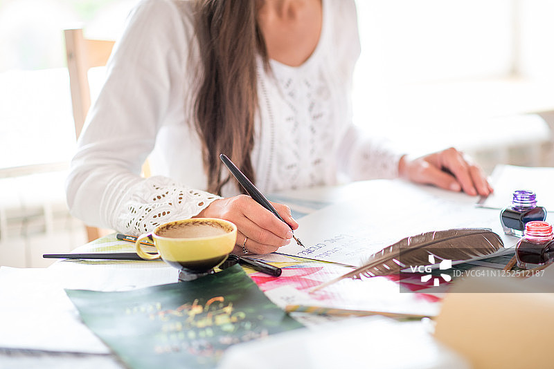 坐在书桌前练习书法的漂亮女人图片素材