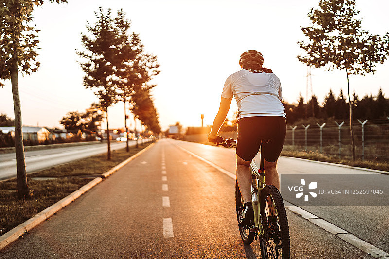 骑行者在日落的路上图片素材