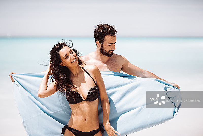 在海边玩耍的夫妇与毛巾图片素材