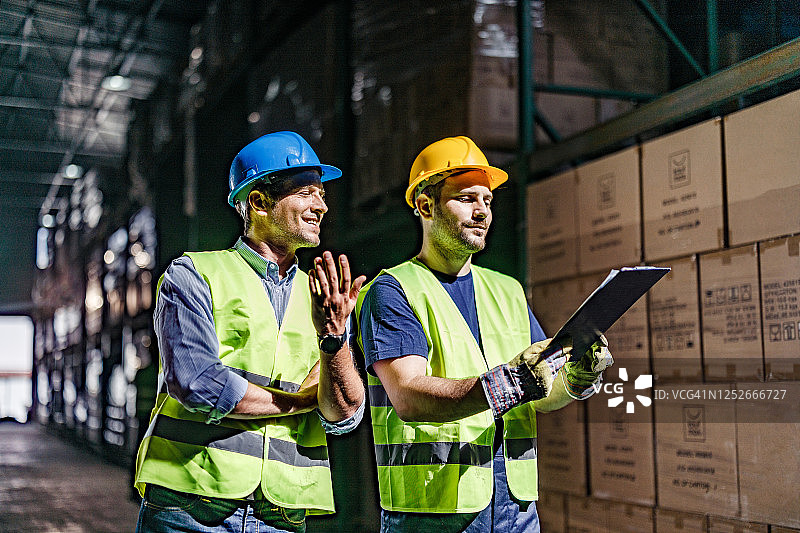 仓库工人及其经理在储藏室里检查清单图片素材