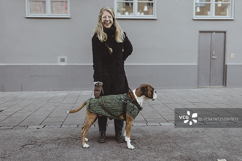 在城市建筑前与拳击手站在一起的快乐年轻女人图片素材
